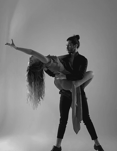 Black and white photo of a man and woman doing an intimate dance.