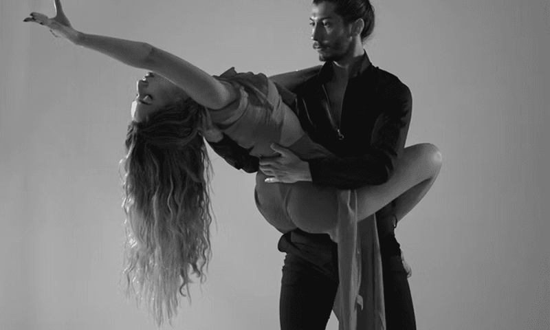 Black and white photo of a man and woman doing an intimate dance.