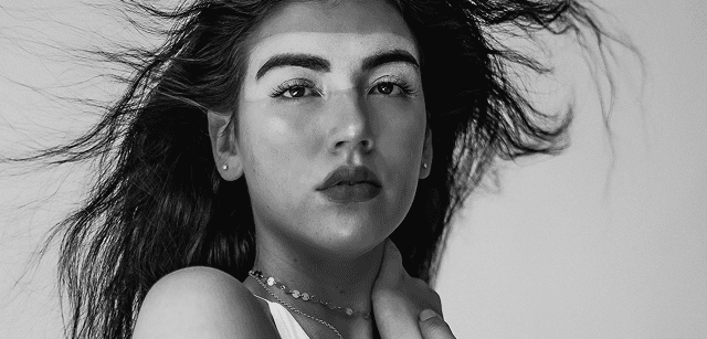 Black and white portrait of a dance instructor against a light background.